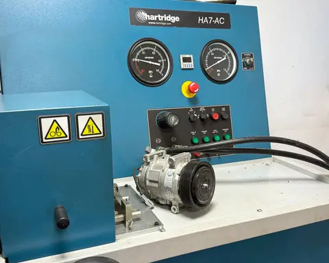 Banco de pruebas de compresores de A/C en la nave de IBAÑEZ CLIMA, con un compresor montado.