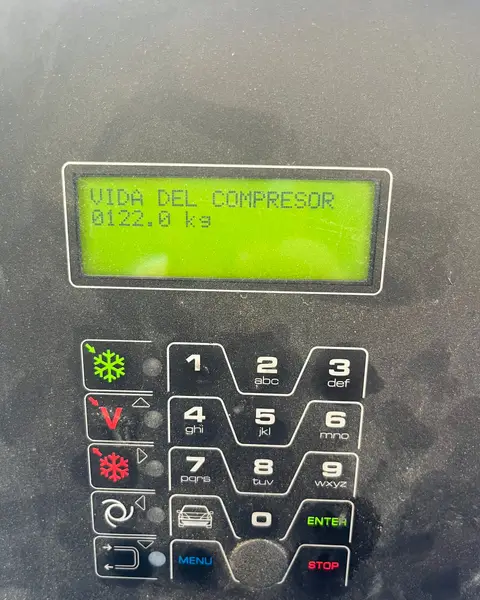 Teclado y pantalla de una estación de carga de aire acondicionado, con el mensaje «Vida del compresor» en el display.