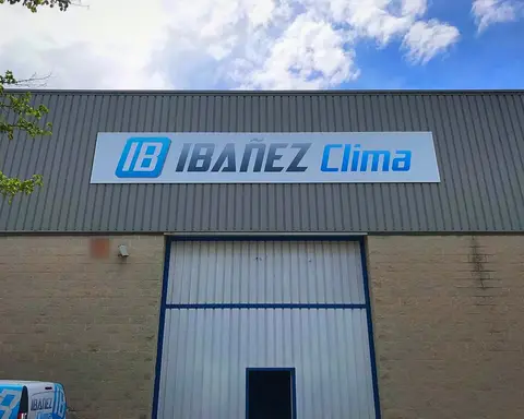 Fachada de la nave de IBAÑEZ CLIMA en Lleida, con el rótulo de la empresa y el portón de entrada.