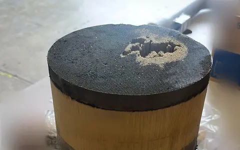 Cerámica de un filtro de partículas fuera de su carcasa, con un cráter abierto en una de sus caras.