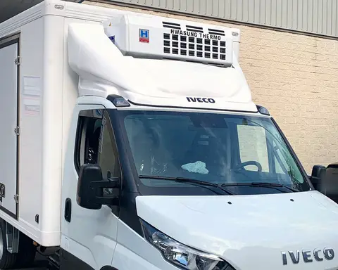 Camión Iveco con caja isoterma y equipo de frío Hwasung Thermo sobre la cabina.