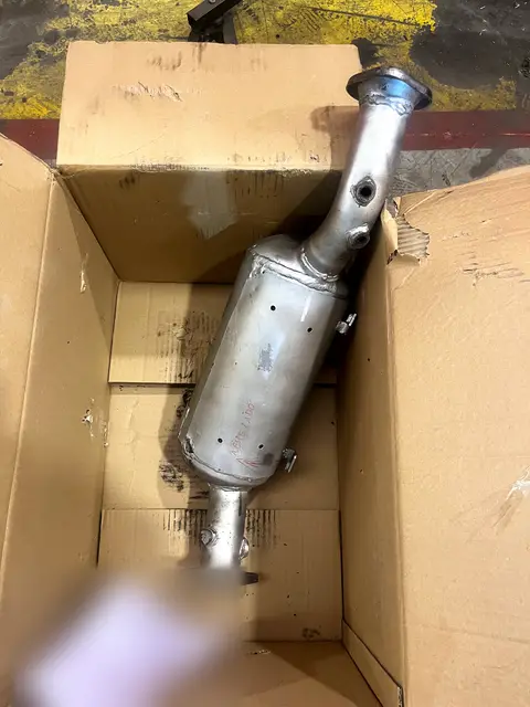 Filtro de partículas dentro de una caja de cartón abierta.